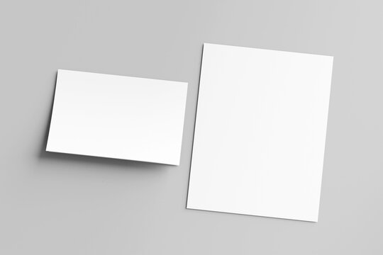 Blank white bi-fold brochures with realistic shadows isolated on gray background. One booklet is closed the second is open on the spread. 3d rendering