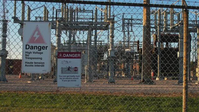 Electrical grid substation and high voltage electric switchyard converter transformer in America. Power station with pylons and distribution cables for city households and EV charging stations.