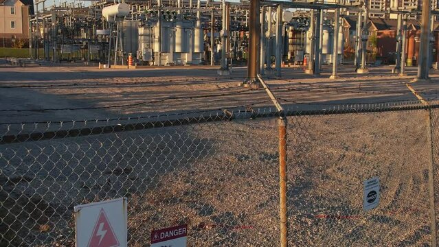 Electrical grid substation and high voltage electric switchyard converter transformer in America. Power station with pylons and distribution cables for city households and EV charging stations.