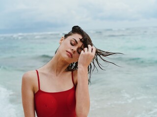 Portrait of a beauty woman on the beach with beautiful tanned skin and wet hair against the ocean...
