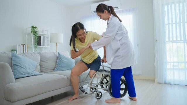 Asian caregiver nurse support female leg amputee sitting on wheelchair