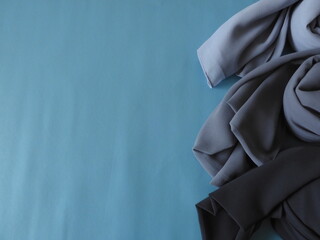 Flat lay grey color fabric on blue  background