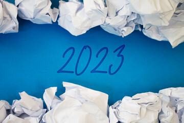 The number 2023 with Torn, Crumpled White Paper on colored background.