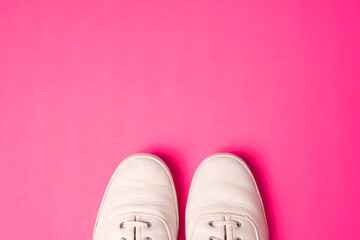 Trendy White Sneakers Top View with Space For Copy Pink Background