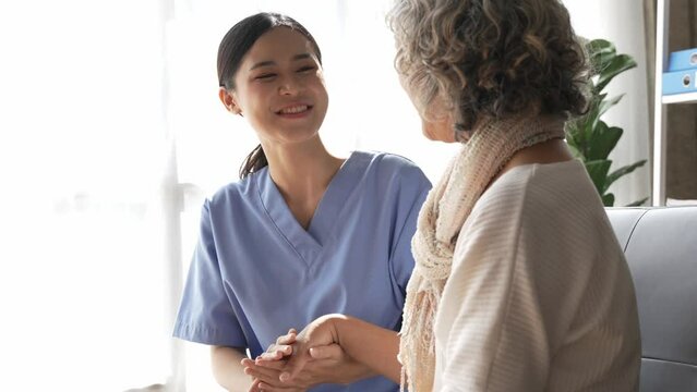 Asian young nurse supporting elderly patient disabled woman in hospital. Elderly patient care concept.