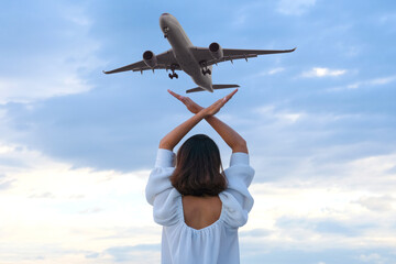 back view of woman waving commercial plane in the sky travel and tourism concept