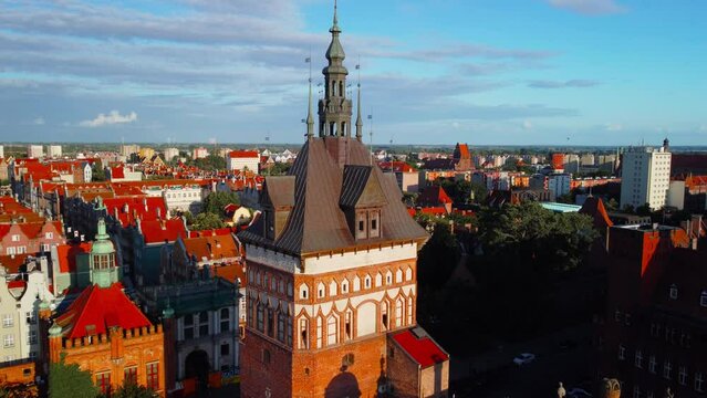 Slow orbit drone flight to the left above rooftops of the old town in Gdansk Poland during warm clean cloudy sky in summer with a panoramic view of Katownia Prison Tower Wyzynna wieza wiezienna