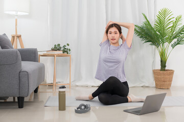 Yoga exercise concept, Young Asian woman stretching and doing yoga exercise training online at home