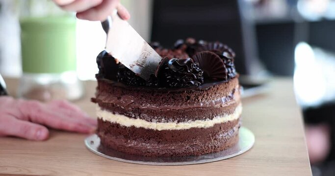 Cutting slice of birthday cake and closeup of knife cutting chocolate cake