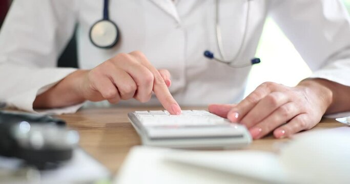 Doctor with calculator calculating costs and income in medical practice and hospital
