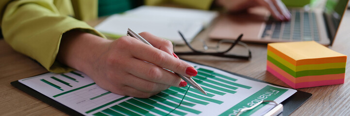 Analyst employee working with financial report on computer and documents
