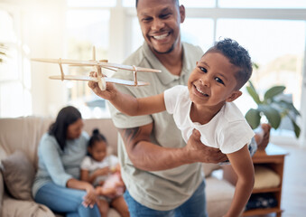 Dad, boy and toy plane in living room for game, fun or bonding while happy together. Father, son and play airplane toys with smile at house with love, happiness or family home lounge in Orlando