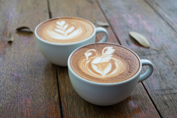 Latte art coffee with swan and heart tree shape in coffee cup on wooden background, Hot drink