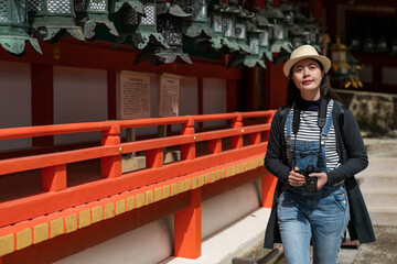 cheerful Asian Chinese female tourist enjoying beautiful scenery while walking past a line of...