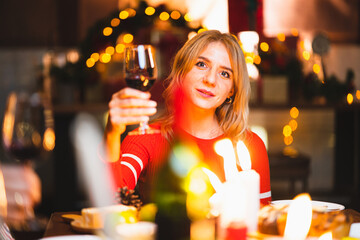 smiling woman holding glass of champagne in christmas day.