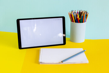 Tablet and notebook for online study on yellow and blue - obrazy, fototapety, plakaty
