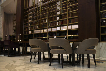 Lobby lounge with sofa chairs and table on marble floor in modern residential building.