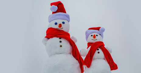Funny Snowmen. Two snowman on snow background.