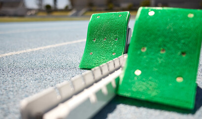 Sports closeup, starting blocks and running track, field or pitch for training, exercise or sprint...