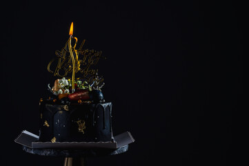 birthday cake and candles on a black background.	