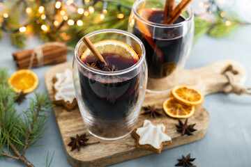 Hot winter drink mulled wine with spices and fresh orange slices in New Year's decorations. Traditional winter drink.