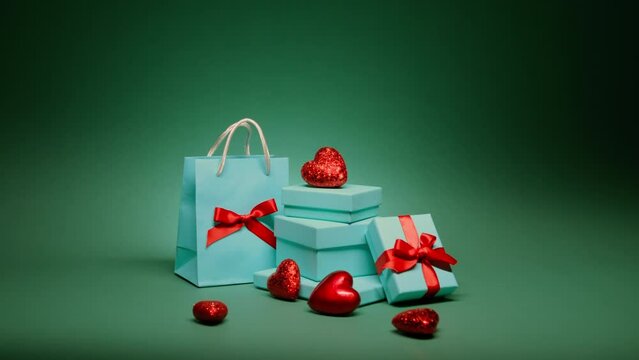Christmas emerald green background night. Surprise gifts with jewelry for Birthday, Anniversary, Christmas eve, New Year party. Beautiful elegant teal blue gift boxes with red hearts isolated