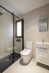Modern empty bathroom with beige tiles, furniture and rectangular mirror