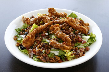Crispy meaty chicken salad with olives and bacon bits