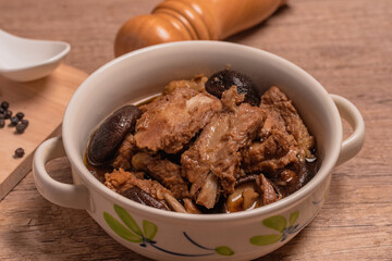 Braised pork ribs with shiitake mushrooms on wooden background