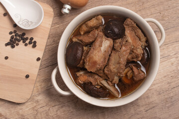 Braised pork ribs with shiitake mushrooms on wooden background
