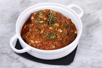 Lamb shoulder chops braised with tomatoes, beans, carrots and olives