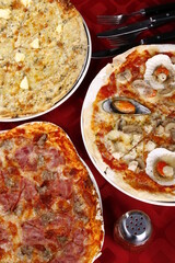 Top shot of three flavors of pizza - all-meat, seafood and four cheese