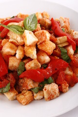 Crouton salad with sliced red bell peppers and basil leaves