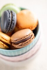 Sweet macaron dessert. Colorful macarons in bowl on kitchen table.