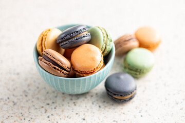 Sweet macaron dessert. Colorful macarons in bowl on kitchen table.