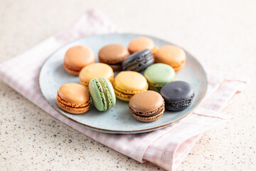 Sweet macaron dessert. Colorful macarons on plate on checkered napkin.