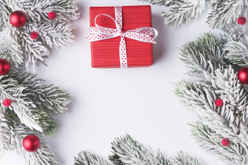 Christmas background with frosty branches and gift box on white background