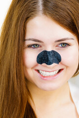Woman applying pore strips on nose
