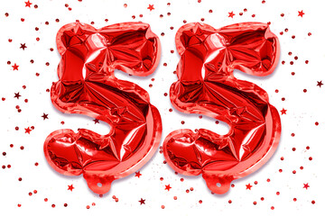 The number of the balloon made of red foil, the number fifty five on a white background with...