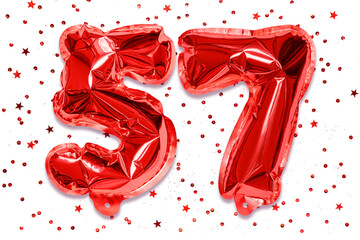 The number of the balloon made of red foil, the number fifty-seven on a white background with...