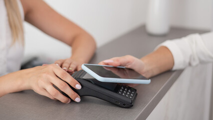 A woman pays using a contactless payment of the NFC used by a smartphone. 