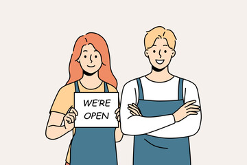 Smiling waiters in aprons hold open sign. Happy man and woman cafe staff notify about shop opening. Vector illustration. 
