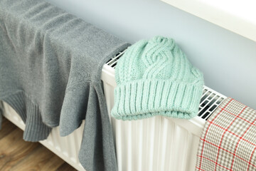 Different winter clothes drying on radiator indoor