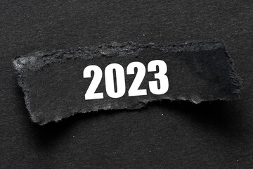 2023 year word on a black piece of paper and a black background.
