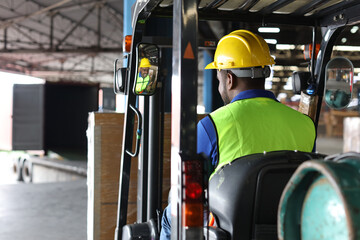 Warehouse workers or forklift driver man with hardhats and reflective jackets in vehicle using walkie talkie radio controlling stock and inventory in retail warehouse logistics, distribution center