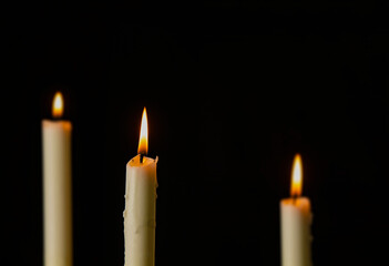 Light of white candles against black background