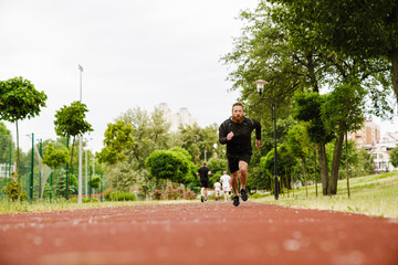 Obraz premium Portrait of adult bearded redhead man running on track