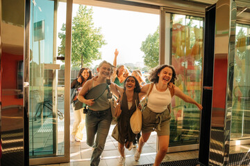 Cheerful teenage girls running and entering in mall