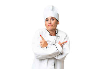 Middle-aged chef woman over isolated background pointing to the laterals having doubts