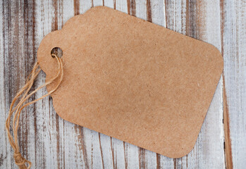 plain cardboard gift tag with twine on rustic wooden surface